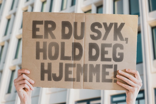 The phrase Stay home when you are sick is on a banner in hand Outbreak Quarantine Infection Pandemic Global epidemic Work Employee You Job Unwell Isolation Nose