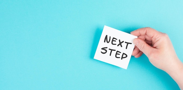 The phrase next step is standing on a paper, having new goals and strategies, making plans