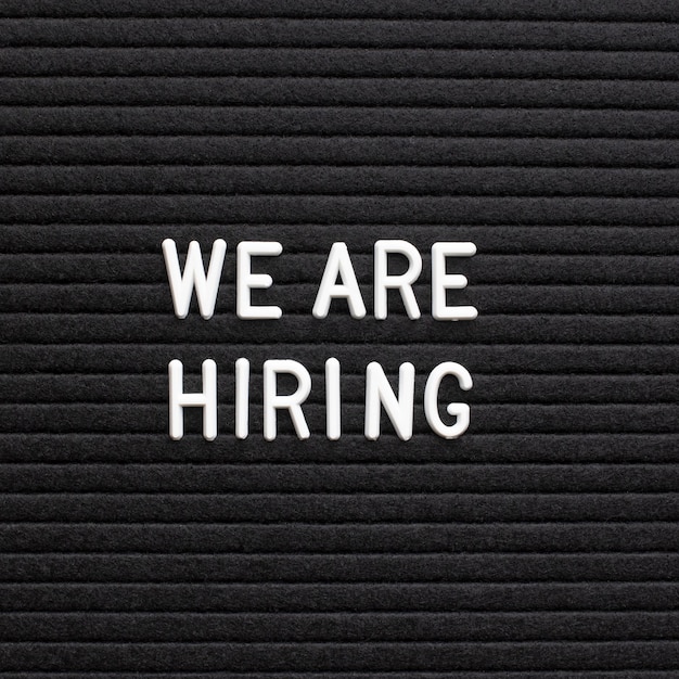 The phrase we are hiring on black letter board