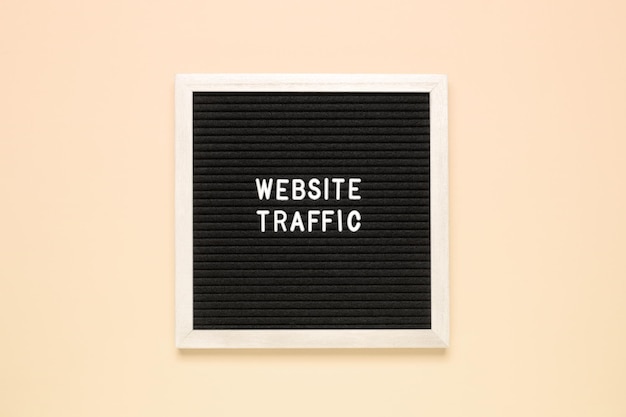 The phrase website traffic on black letter board over isolated beige background