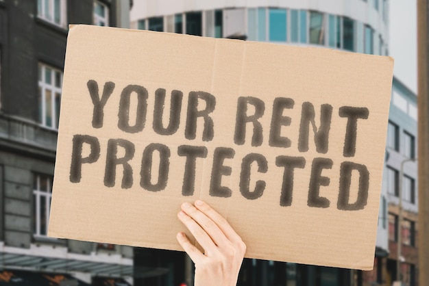 Photo the phrase your rent protected on a banner in men's hand with blurred background crime budget wealth system key strong net defend secured owner risk secure contract money customer