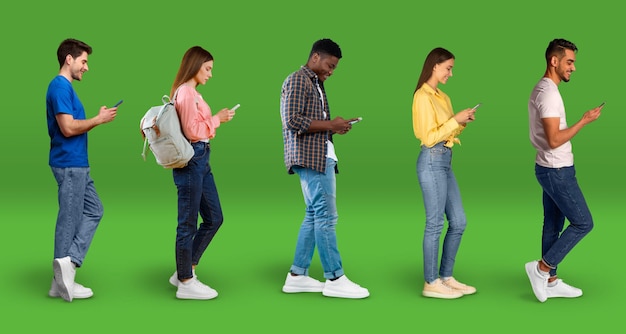 Phubbing Concept Diverse multiculturele mannen en vrouwen die smartphones gebruiken op groene achtergrond