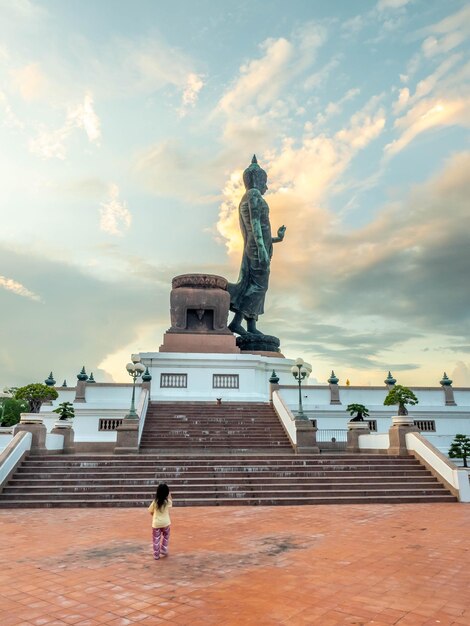 タイの夕方の曇り空の下でプッタモントン仏像を歩く