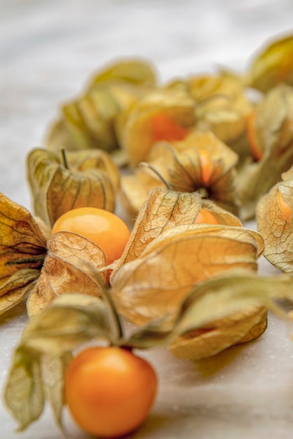 Foto frutti di physalis, physalis peruviana, su uno sfondo chiaro. bacca dorata, frutti maturi di physalis.