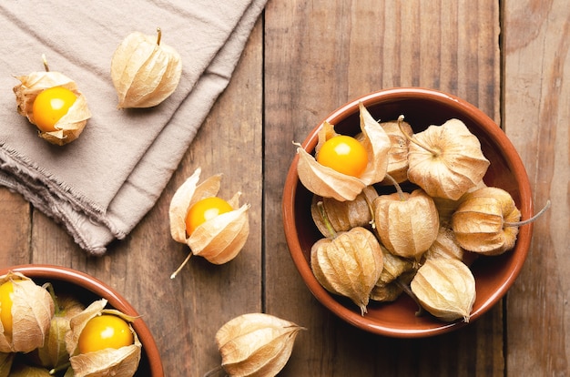 Physalis Peruaanse vruchten in bruine kommen op een houten ondergrond