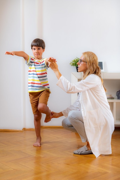 Physical therapist doing balance test medical exam with a boy