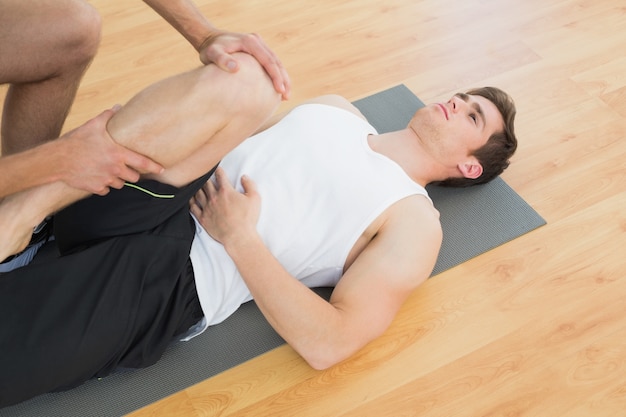 Physical therapist examining young mans leg