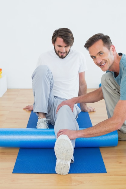 Physical therapist examining young mans leg