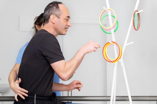 Photo physical therapist helping to disabled male patient supporting during exercise therapy