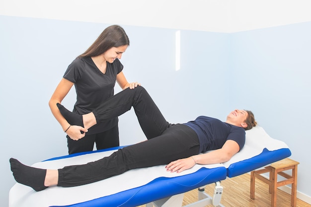 A physical therapist performs lower limb mobilization