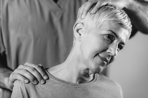 Physical Therapist Stretching Senior Woman's Neck