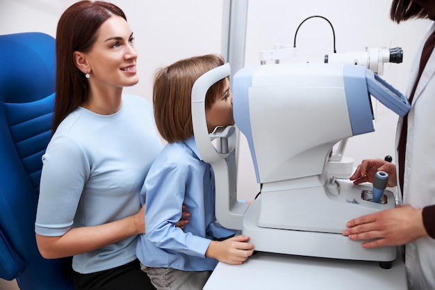 Physician checking boy eyesight at an autorefractor