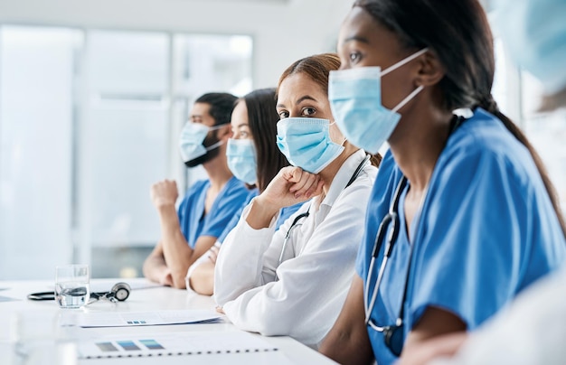 Photo physician integration will be key for this case portrait of a doctor sitting alongside her colleagues during a meeting in a hospital boardroom