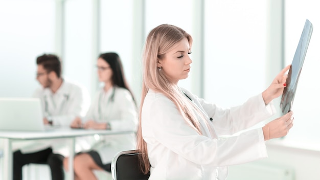 physician therapist looks at the xray of the patient