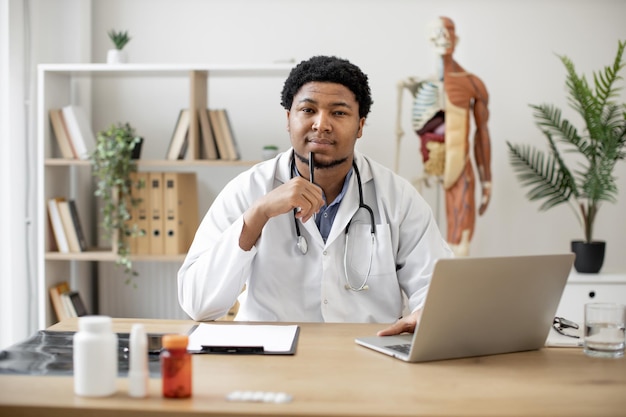 Physician typing on laptop and making notes in clinic