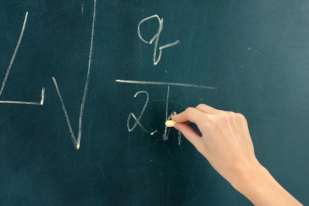 Physics formula written on blackboard with chalk