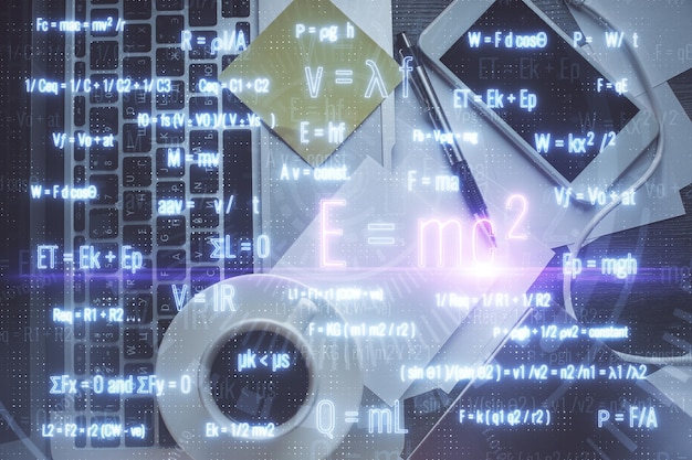 Голограмма на тему физики и математики с рисунками формул на компьютере на заднем плане рабочего стола Верхний вид Многократная экспозиция Концепция образования.