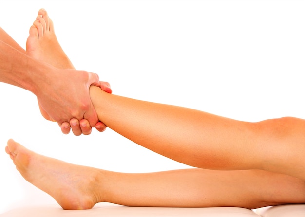 a physio therapist giving a leg massage over white