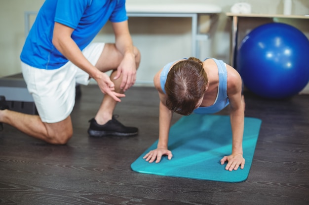 Physiotherapist assisting a female patient while exercising