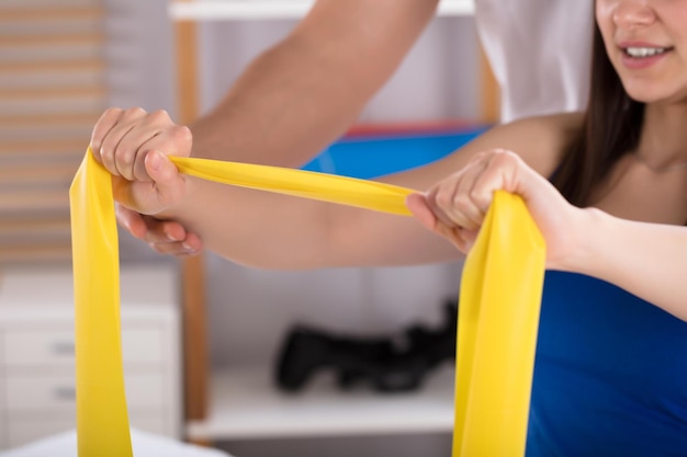 Physiotherapist Assisting Woman While Doing Exercise