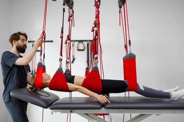 Physiotherapist assists female patient undergoing rehabilitative physiotherapy