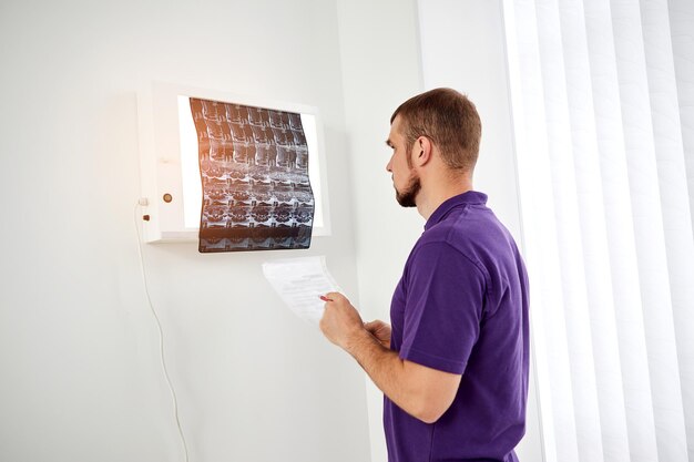 The physiotherapist doctor examining Xray or mri picture in privat clinic Surgeon or orthopedic in rehabilitation center Medicine and healthcare concept