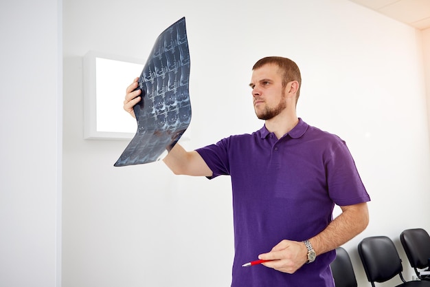 The physiotherapist doctor examining Xray or mri picture in privat clinic Surgeon or orthopedic in rehabilitation center Medicine and healthcare concept