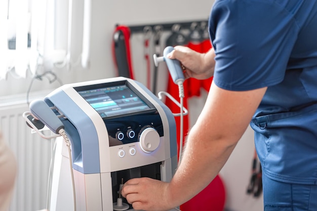 physiotherapist doctor uses medical equipment for effective pain treatment
