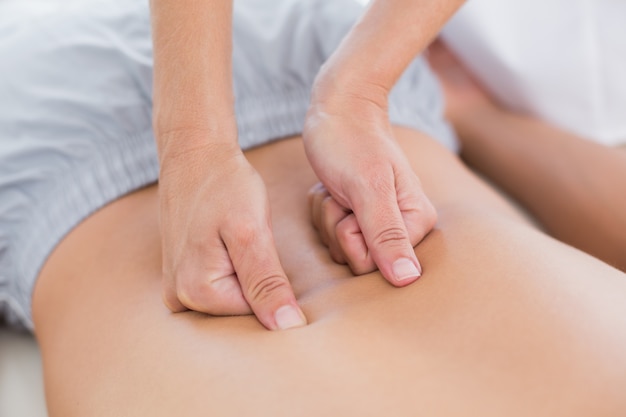 Physiotherapist doing back massage to her patient