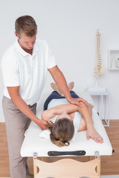 Physiotherapist doing back massage to her patient