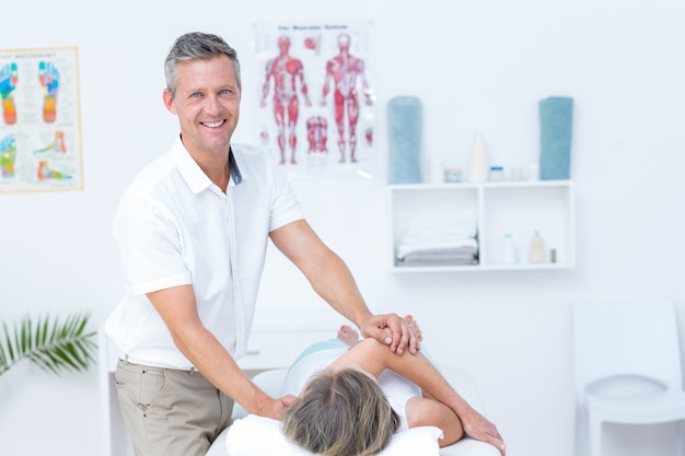 Physiotherapist doing back massage to his patient