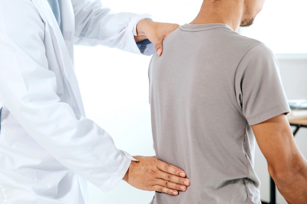 Photo physiotherapist doing healing treatment on man's back. back pain patient, massage therapist