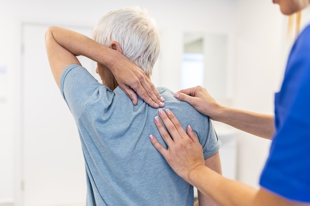 Foto fisioterapeuta che esegue un trattamento di guarigione sulla schiena della donna trattamento del paziente con dolori alla schiena il medico consulta il paziente con problemi alla schiena concetto di terapia fisica