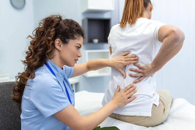 Foto fisioterapista che esegue un trattamento curativo sulla schiena della donna sindrome dell'ufficio del massaggiatore medico per il trattamento del paziente con dolore alla schiena