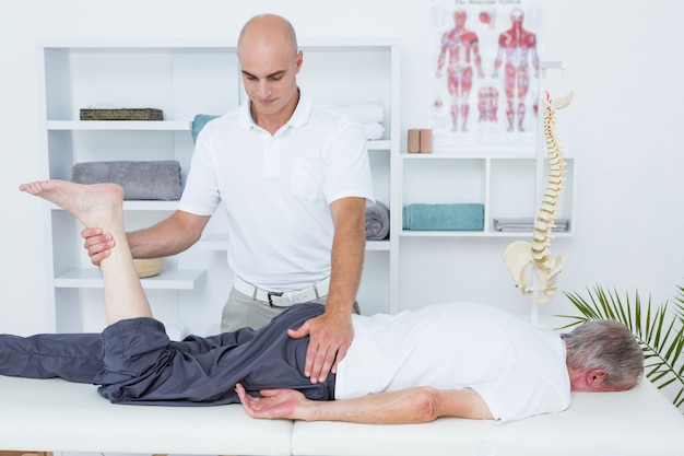 Physiotherapist doing leg massage to his patient