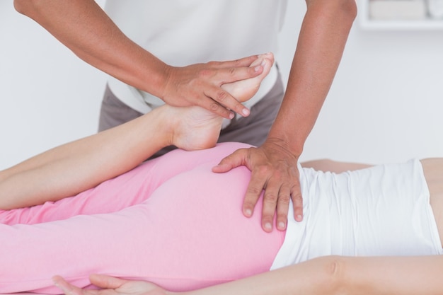 Physiotherapist doing leg massage to his patient