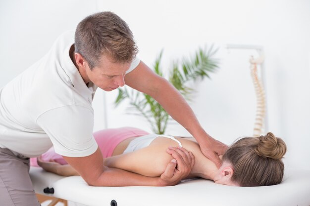 Physiotherapist doing neck massage to his patient