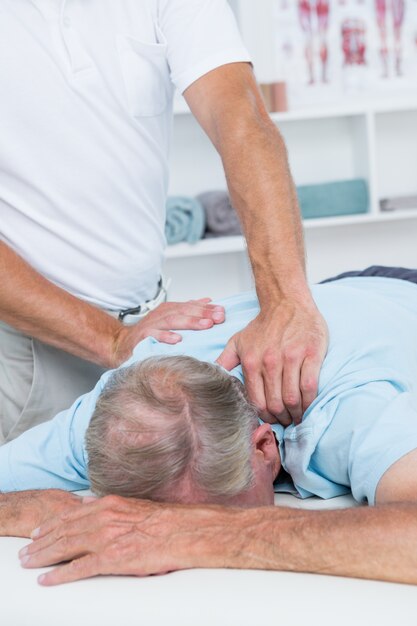 Photo physiotherapist doing neck massage to his patient