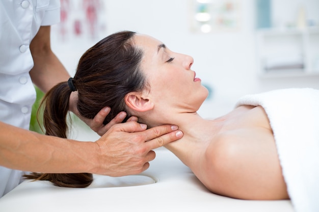 Foto fisioterapista facendo massaggio al collo