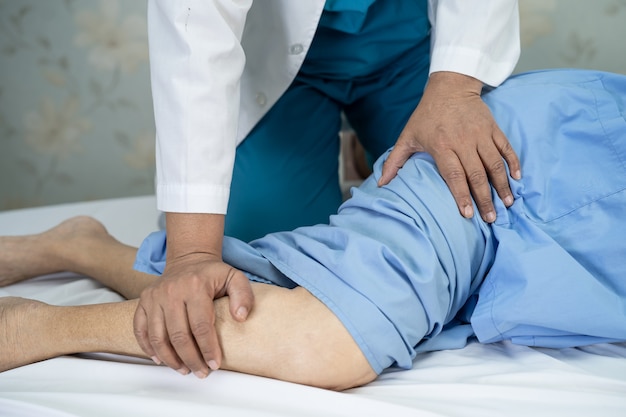 physiotherapist doing physical therapy in hospital.