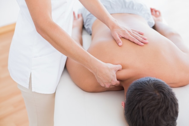 Photo physiotherapist doing shoulder massage to her patient