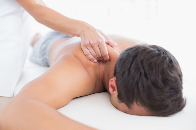 Physiotherapist doing shoulder massage to her patient