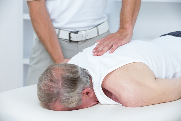 Physiotherapist doing shoulder massage to his patient in medical office