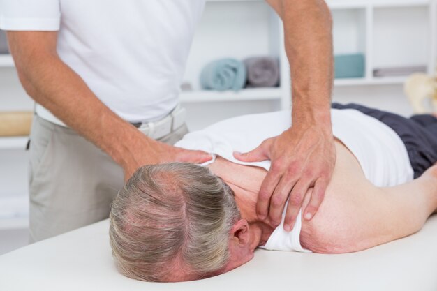 Physiotherapist doing shoulder massage to his patient