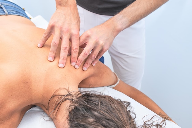 Physiotherapist during a woman\'s scapula back treatment