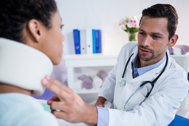 Physiotherapist examining a female patients neck