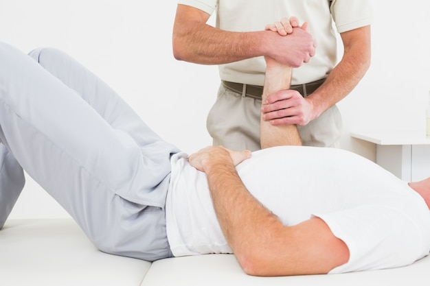 Physiotherapist examining a mans hand