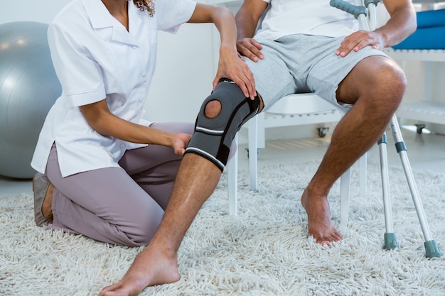 Физиотерапевт осматривает пациентов коленного сустава