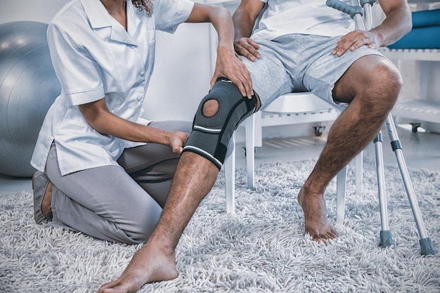 Physiotherapist examining patients knee