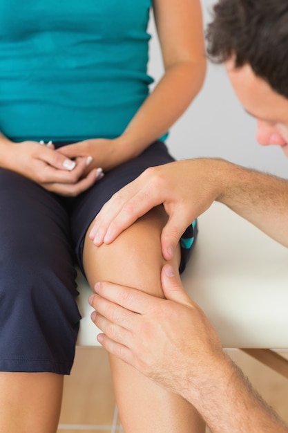 Physiotherapist examining patients knee